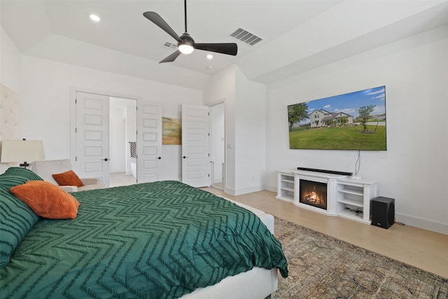 bedroom with a fireplace, ceiling fan, and lofted ceiling