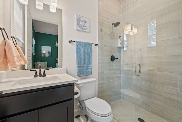 bathroom with a shower with door, vanity, and toilet