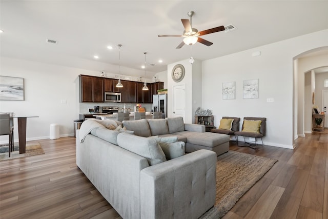 living room with light hardwood / wood-style floors and ceiling fan