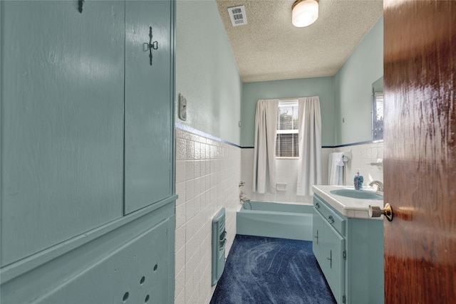 bathroom with shower / bath combination with curtain, vanity, heating unit, a textured ceiling, and tile walls