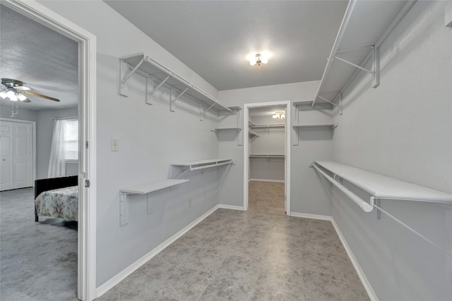 walk in closet with ceiling fan