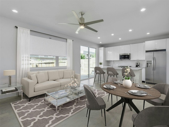 living area with light wood-style flooring, recessed lighting, and ceiling fan