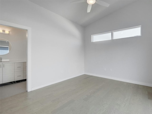 unfurnished room with ceiling fan, lofted ceiling, wood finished floors, and a sink