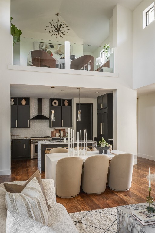 living room with sink, a high ceiling, and dark hardwood / wood-style flooring