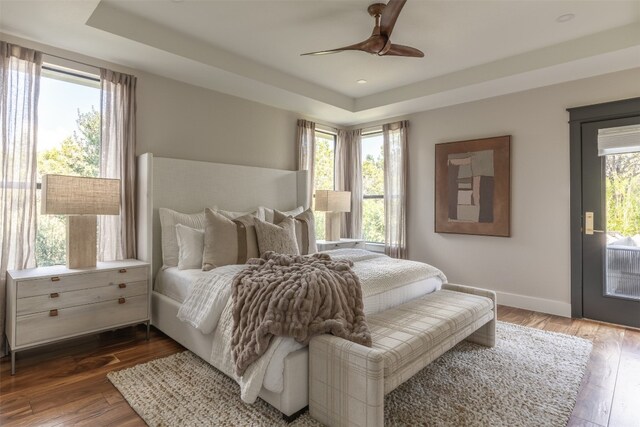 bedroom featuring multiple windows, hardwood / wood-style floors, and ceiling fan