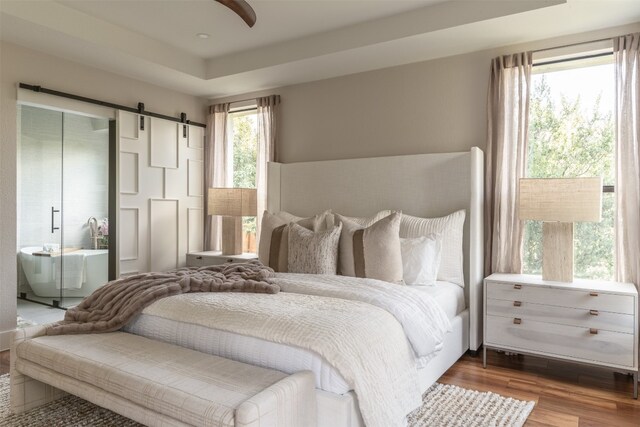 bedroom with hardwood / wood-style floors and a barn door