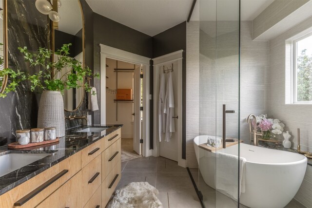 bathroom with vanity, a washtub, and tile patterned flooring