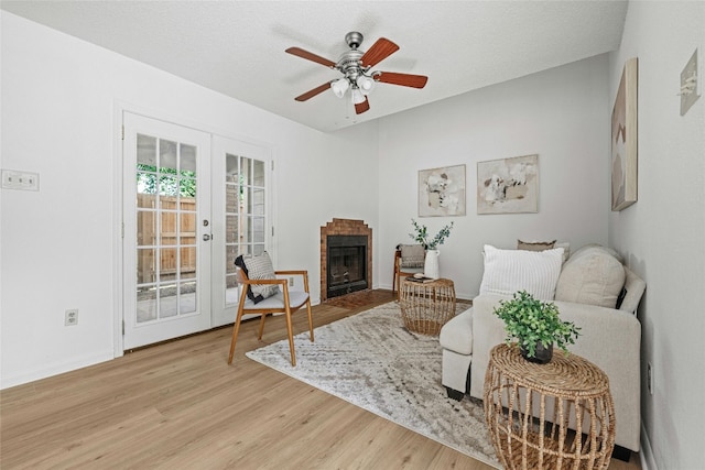 living area with light hardwood / wood-style flooring, french doors, a textured ceiling, and ceiling fan