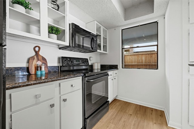 kitchen with black appliances, light wood-type flooring, a textured ceiling, white cabinets, and dark stone countertops