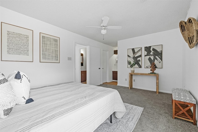 bedroom featuring connected bathroom, a textured ceiling, carpet flooring, and ceiling fan