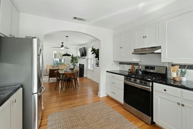 kitchen with appliances with stainless steel finishes, white cabinets, visible vents, and under cabinet range hood