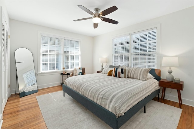 bedroom featuring light wood finished floors, ceiling fan, and baseboards