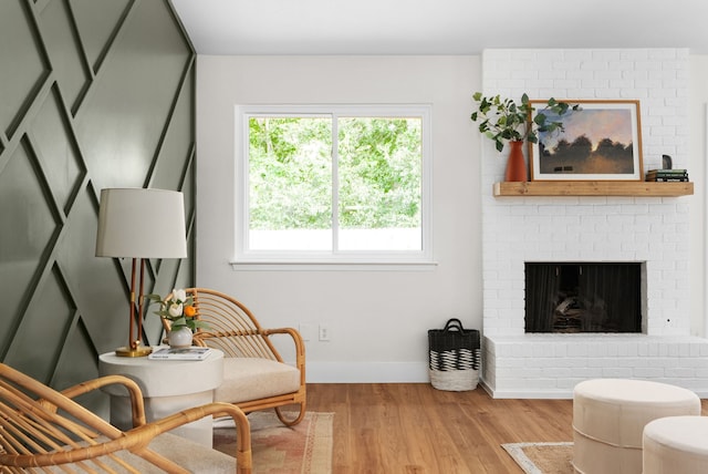 sitting room with a fireplace and light hardwood / wood-style flooring