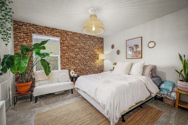 bedroom with brick wall and carpet