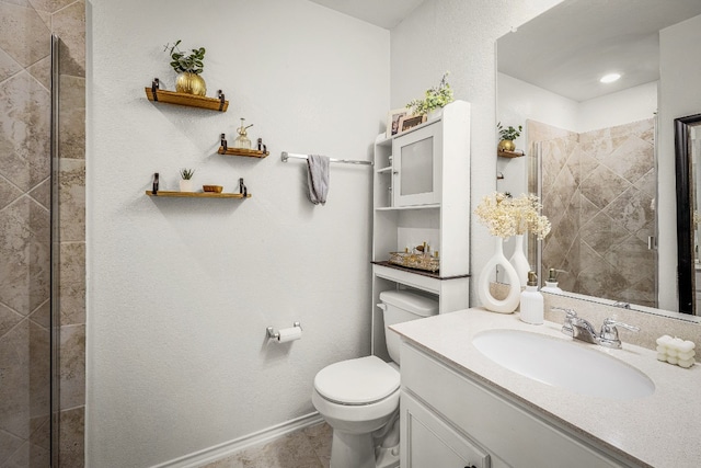 bathroom with a tile shower, toilet, and vanity