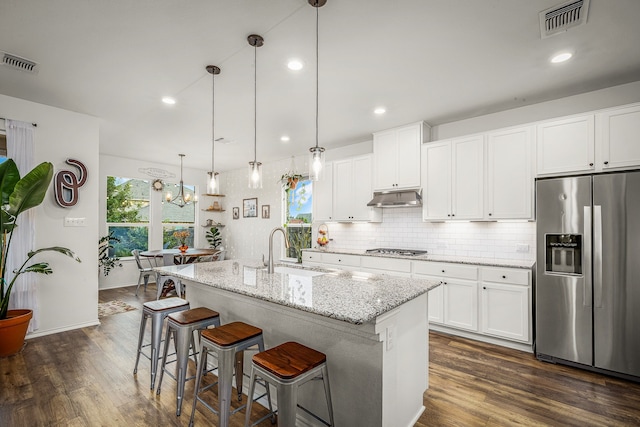 kitchen featuring appliances with stainless steel finishes, white cabinetry, a kitchen island with sink, sink, and pendant lighting