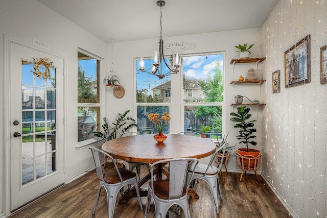 dining space with dark hardwood / wood-style floors and a notable chandelier