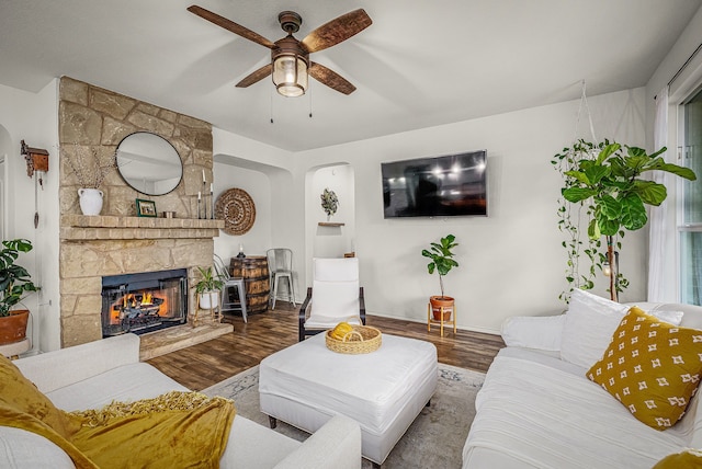 living room with hardwood / wood-style flooring, ceiling fan, and a fireplace