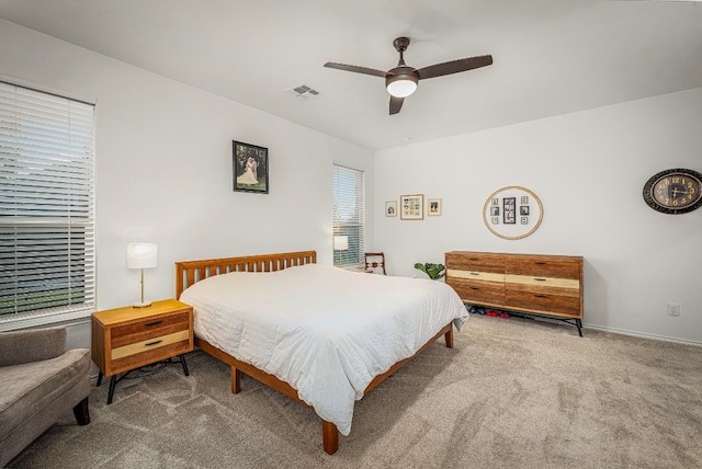 bedroom featuring light carpet, multiple windows, and ceiling fan