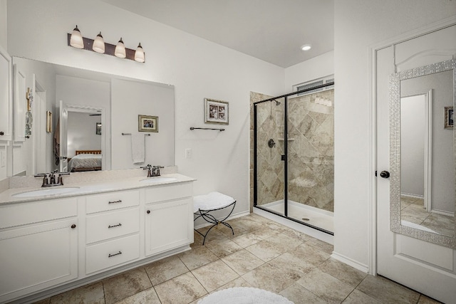 bathroom featuring a shower with door and vanity