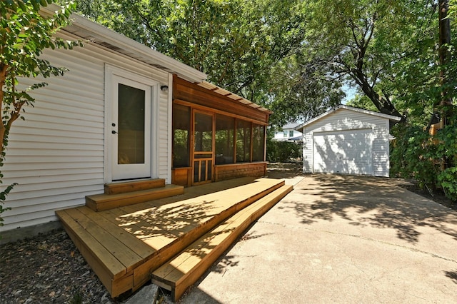 exterior space featuring a sunroom, a garage, and an outdoor structure