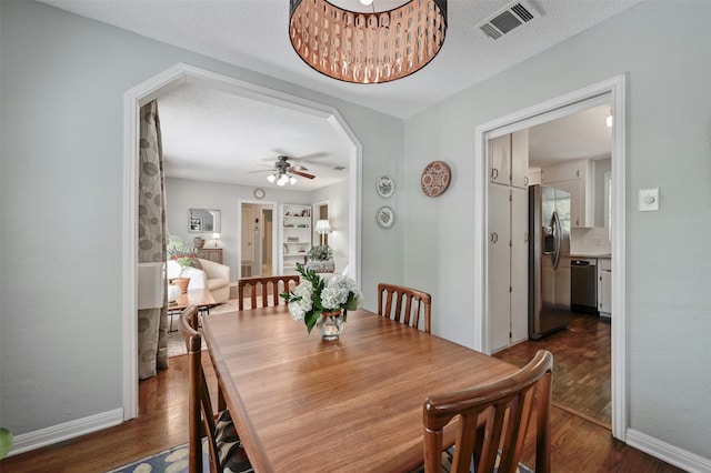 dining room with a textured ceiling, dark hardwood / wood-style flooring, and ceiling fan