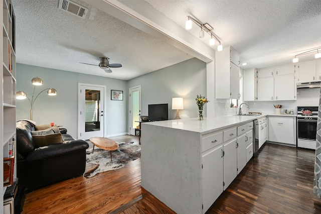 kitchen with kitchen peninsula, sink, stainless steel dishwasher, white range oven, and white cabinetry