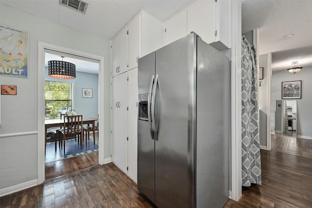 kitchen featuring stainless steel fridge, a textured ceiling, white cabinetry, and dark wood-type flooring