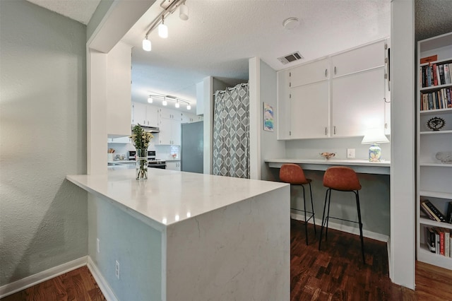 kitchen with kitchen peninsula, appliances with stainless steel finishes, and white cabinetry