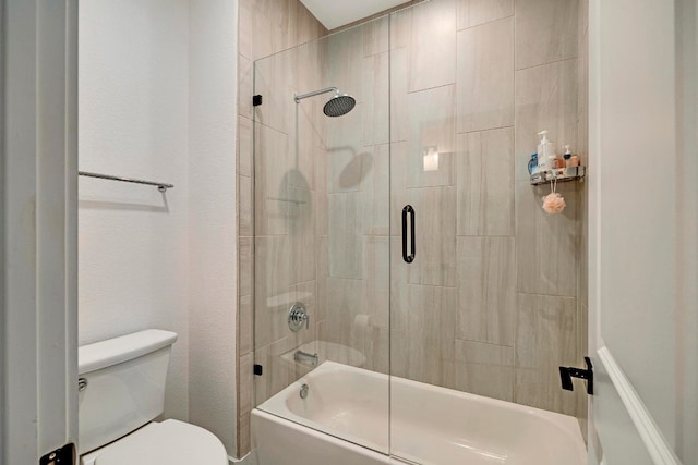 bathroom featuring bath / shower combo with glass door and toilet