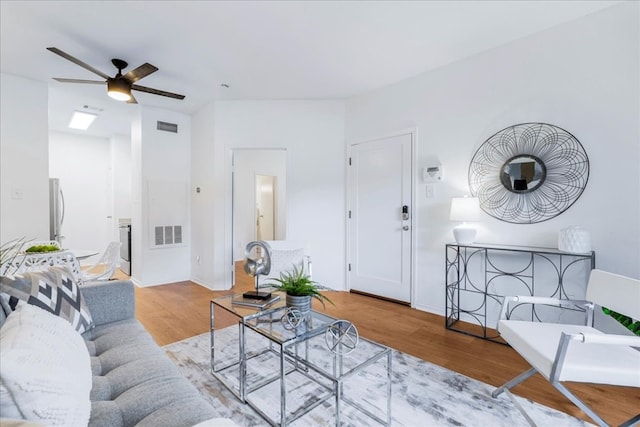 living room featuring ceiling fan and light hardwood / wood-style flooring