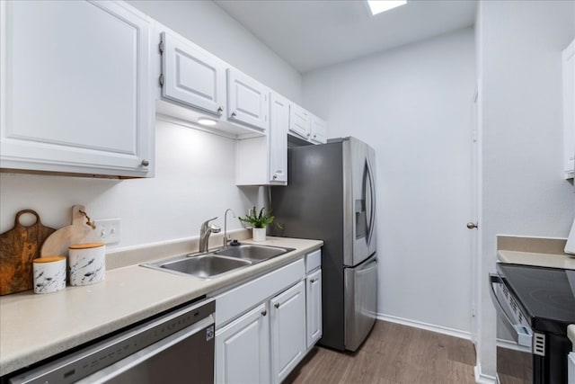 kitchen featuring white cabinets, appliances with stainless steel finishes, sink, and light hardwood / wood-style flooring