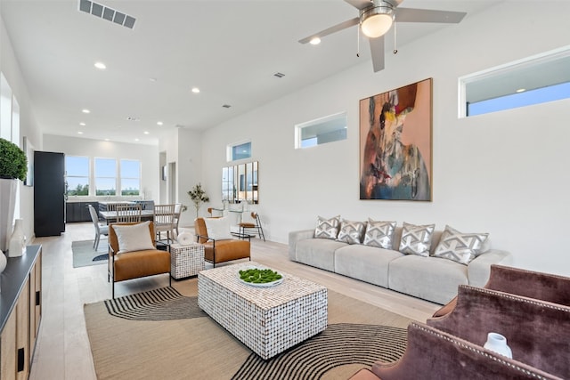 living room featuring light hardwood / wood-style flooring and ceiling fan