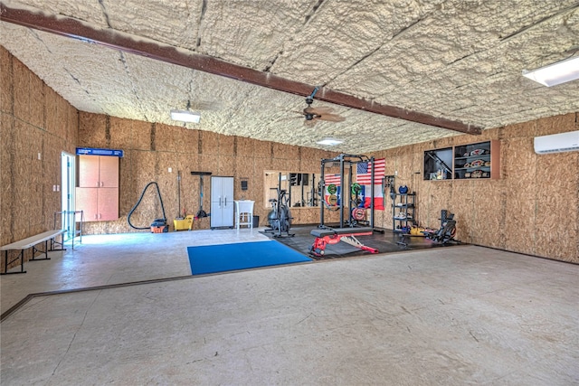 garage featuring an AC wall unit and ceiling fan