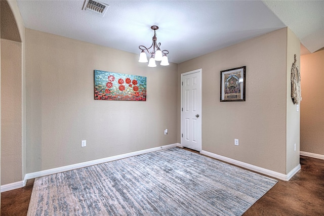 carpeted spare room featuring a notable chandelier