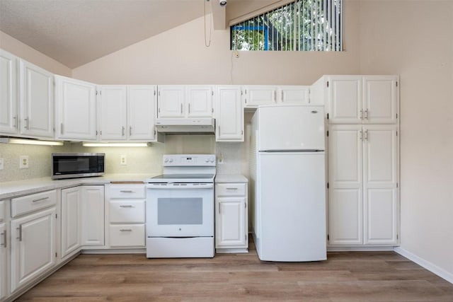 kitchen with under cabinet range hood, tasteful backsplash, white appliances, light countertops, and white cabinets