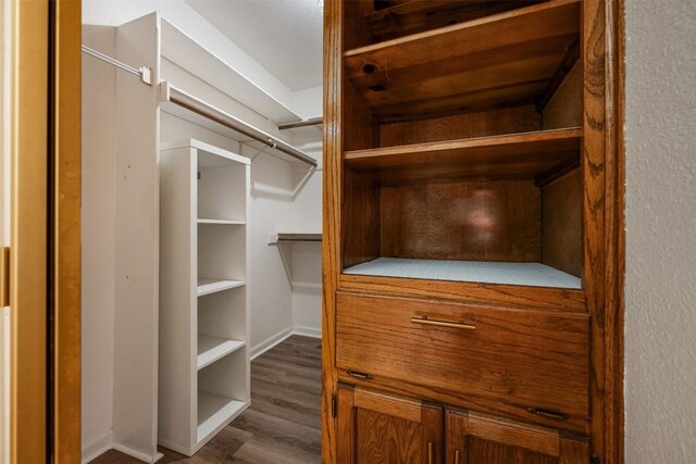 spacious closet with dark hardwood / wood-style flooring