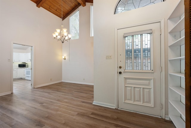 foyer featuring wooden ceiling, a notable chandelier, wood finished floors, baseboards, and beam ceiling