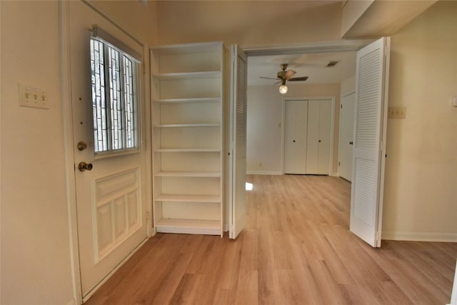 interior space with a ceiling fan, light wood-type flooring, and baseboards