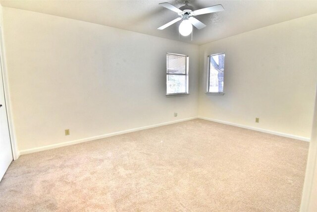 unfurnished room with light carpet, ceiling fan, and baseboards