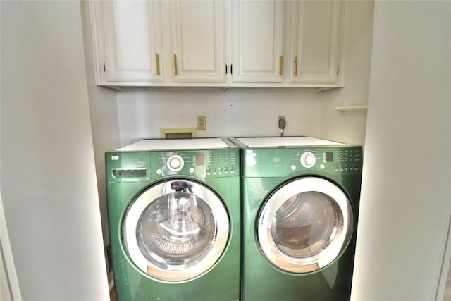 clothes washing area featuring cabinet space and washer and dryer