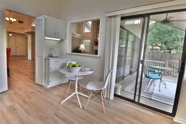 interior space featuring a sink, ceiling fan, light wood-type flooring, and visible vents
