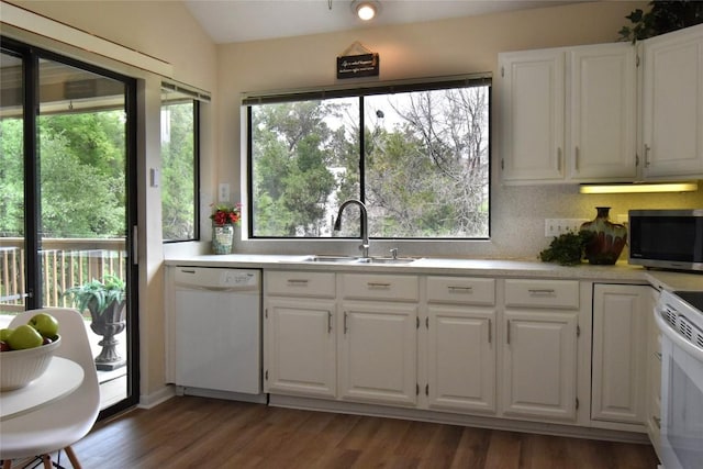 kitchen with light countertops, white cabinetry, a sink, and white appliances