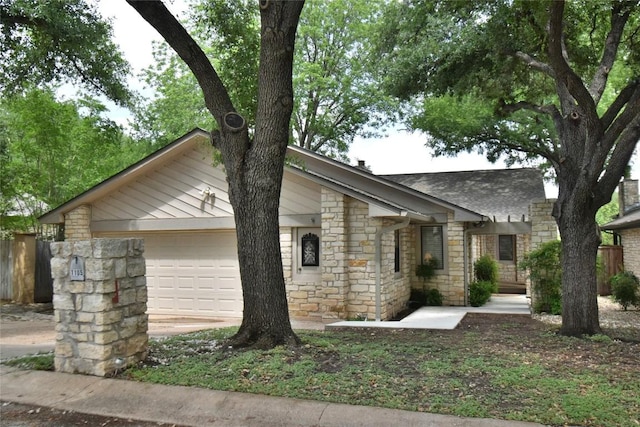 mid-century modern home with stone siding, a garage, and fence