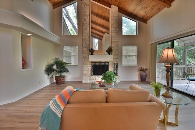 living room with beamed ceiling, a fireplace, high vaulted ceiling, and wood ceiling