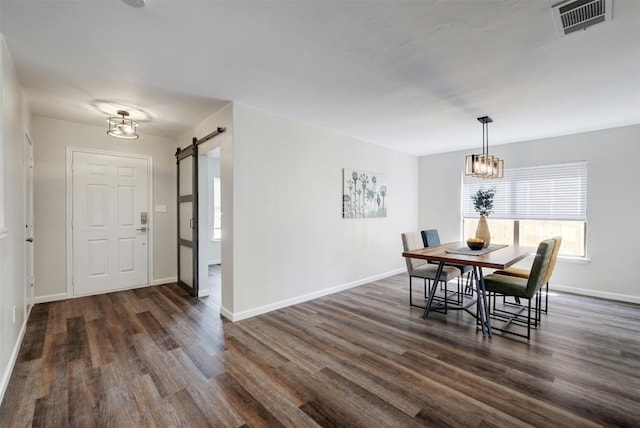 dining room with dark hardwood / wood-style floors and a barn door