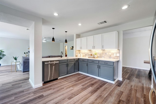 kitchen with light hardwood / wood-style flooring, white cabinets, appliances with stainless steel finishes, and pendant lighting