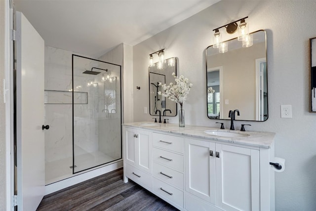 bathroom with a tile shower, vanity, and hardwood / wood-style floors