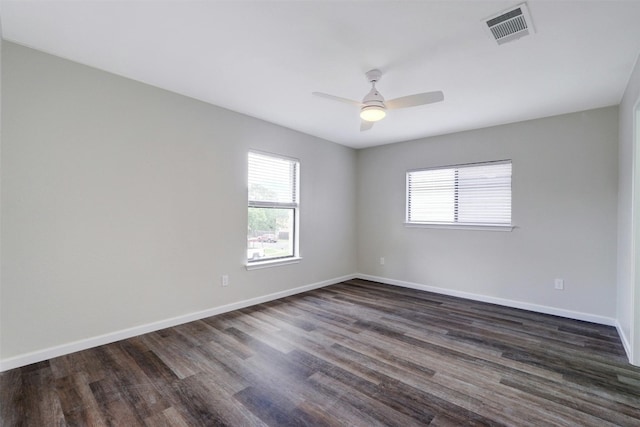 spare room with ceiling fan, dark hardwood / wood-style floors, and a wealth of natural light