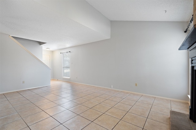 unfurnished living room featuring vaulted ceiling, a textured ceiling, and light tile patterned flooring